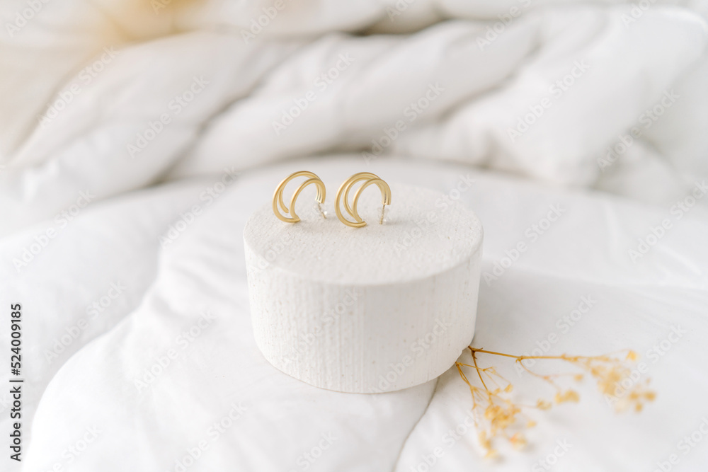 Golden modern bijouterie earrings on white background.