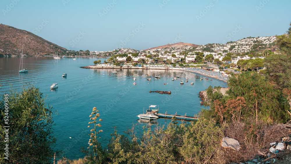 View of Bodrum Beach, Aegean sea, traditional white houses, flowers, marina, sailing boats, yachts in Bodrum town Turkey. Front view