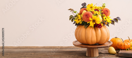 Beautiful autumn bouquet in pumpkin on table against light background. Banner for design