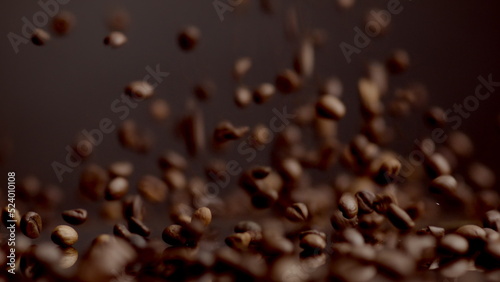 Coffee seeds dawnfall closeup. Roasted beans falling down on table bouncing.
