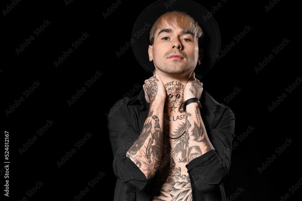 Young tattooed man on black background Young tattooed man on black background