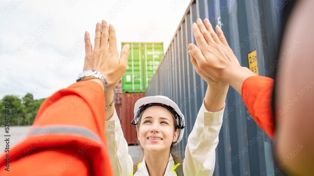 Obraz premium Success Woman manager and foreman Trust hand Hi Five hand after success project logistics business in front of Cargo concainer in warehouse , Manager in white helmet Safety Supervisor warehouse