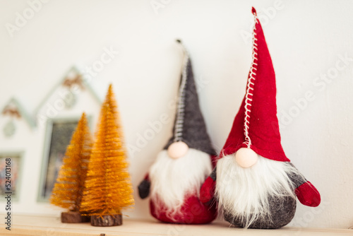 Christmas Decor Closeup. Handmade Gnomes with Red and Gray Caps. Golden Christmas Tree Figurine