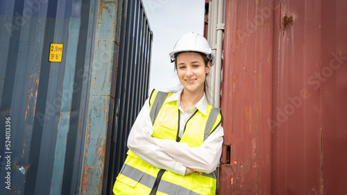 Woman foreman smile at side of Cargo container in warehouse , Manager in white helmet Safety Supervisor in Container Custom Terminal port concept import export