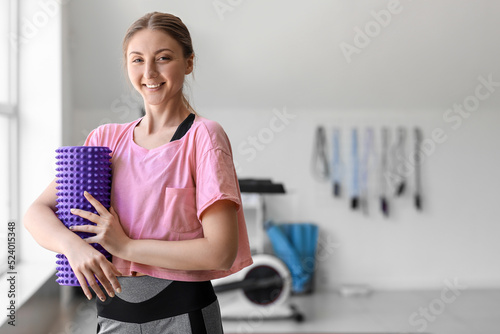 Young woman with foam rolle...