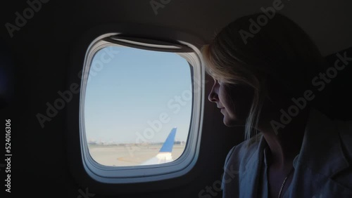 Wallpaper Mural A female passenger looks out the window of the plane, which begins to accelerate along the runway. Torontodigital.ca