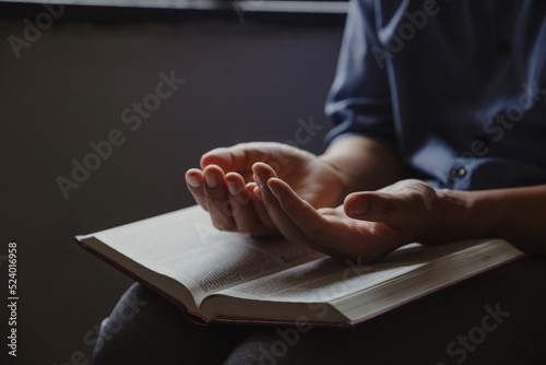 Photo Hands of man prayer to God along with the bible, Concept of faith