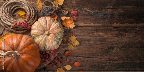 Pumpkins and autumn foliage on a wooden background. Happy Halloween, Thanksgiving. Copy space