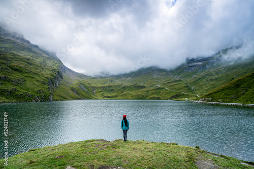 Young woman standing in front of Bachalpsee, Bernese Oberland, Grindelwald, Switzerland