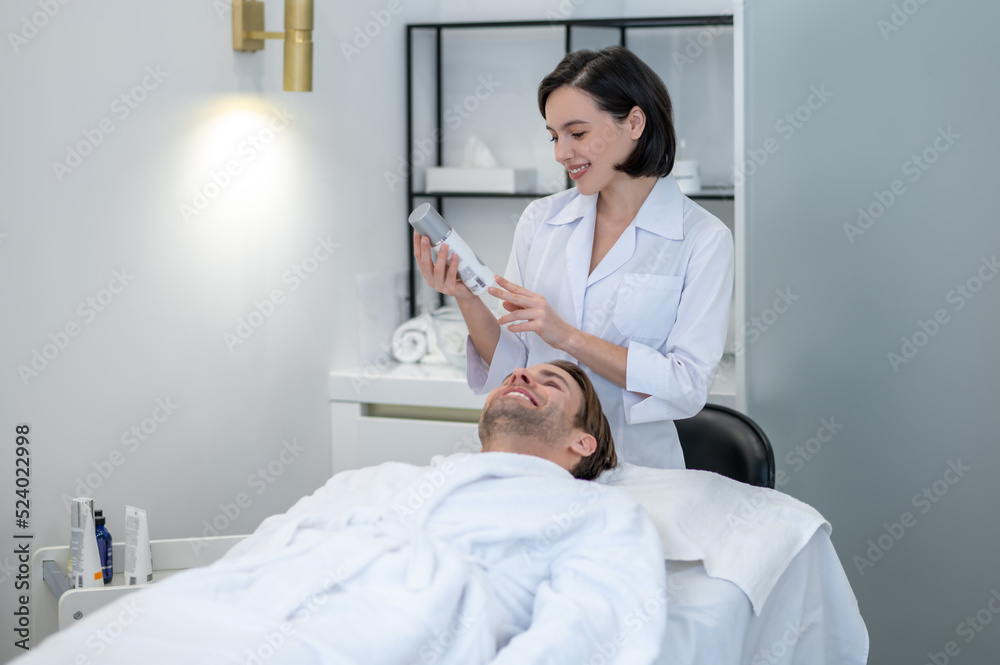 Obraz premium Young woman in lab coat working with a customer in a beauty salon