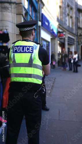 Police officer on duty on a city centre street during special event. 