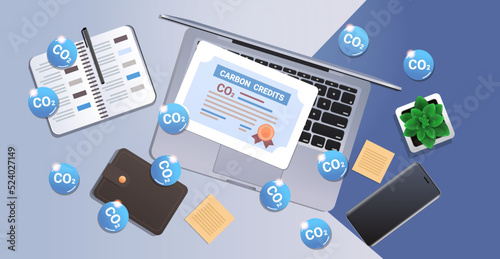 top view of workplace desk wit carbon credits certificate on laptop responsibility of co2 emission environment strategy