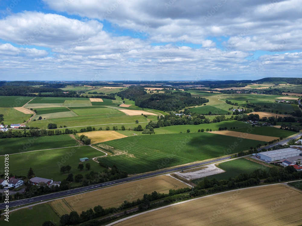 Aerial view of fields of corn and wheat of German farms between forest