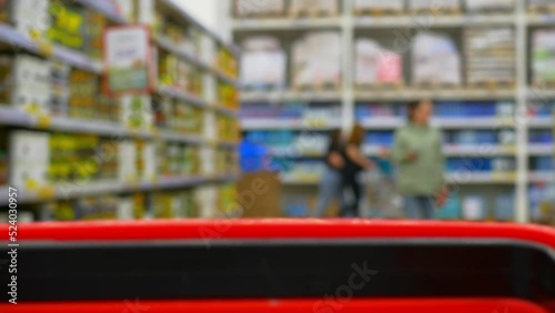 Wallpaper Mural A blurry view from a shopping cart of unrecognizable shoppers walking between supermarket shelves choosing food. Shopping at a local store view from a shopping cart in motion. Torontodigital.ca