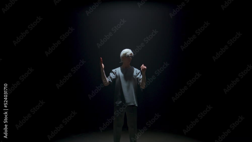 Cyber man experiencing virtual reality in dark room. Futuristic guy swiping air