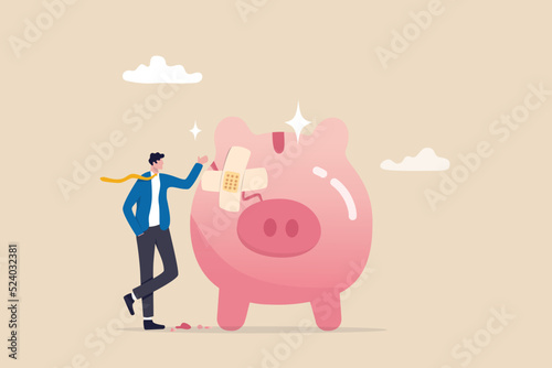 Fix financial problem, investment or saving impacted by crisis or inflation, bankruptcy, deposit or budget concept, poor cracked piggy bank with bandage metaphor of fixing problem. photo