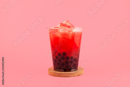 Watermelon boba drink or fruits bubble tea in disposable plastic take away cup. Refreshing cocktail on pink background. Summer iced drink