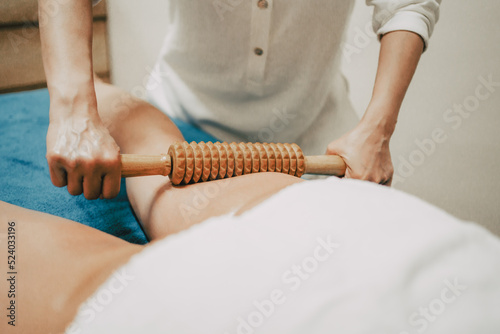masseur doing a massage with a tool in her beauty center