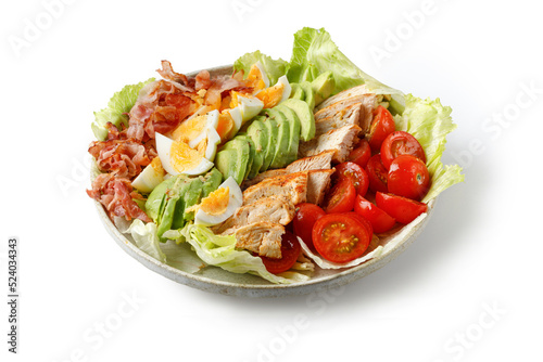 Cobb salad with bacon, avocado, tomato, grilled chicken, eggs isolated on white background. American food. Healthy Keto diet.