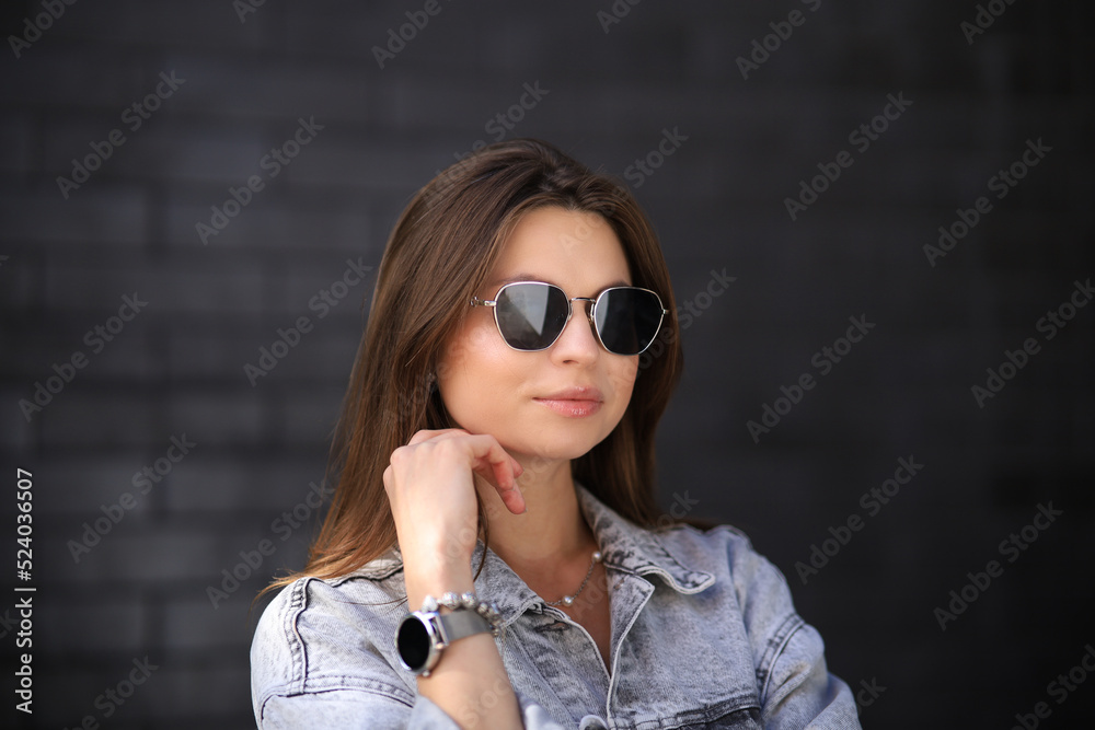 Close up portrait of a fashionable young woman in modern sunglasses over brick wall background. Street style. Beauty, fashion concept. Optics, eyewear. Close up portrait of a fashionable young woman in modern sunglasses over brick wall background. Street style. Beauty, fashion concept. Optics, eyewear.