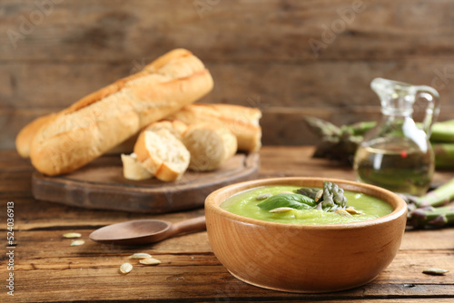 Delicious asparagus soup served on wooden table