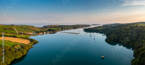 warm evening light over Castlehaven Bay with many sailboats anchored