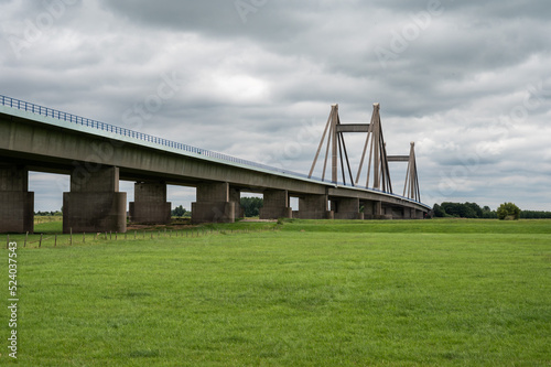 Tiel, Gelderland, The Netherlands, Concrete suspension bridge of the A15 highway surrounded by green meadows © Werner