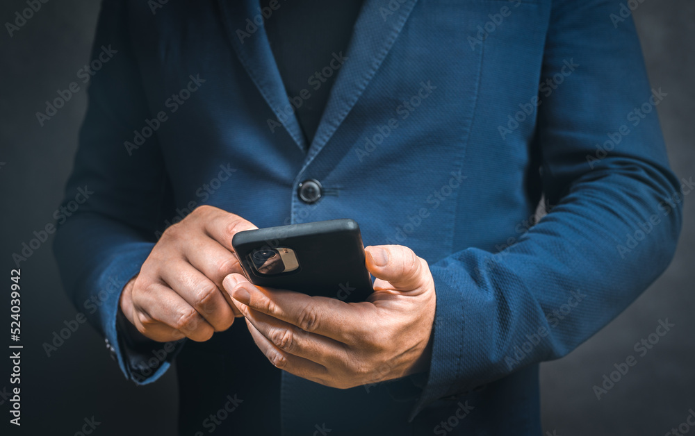 man in suit holding smart phone. Businessman touching screen modern mobile phone. Close-up of businessman using cell phone. dark background, copy space man in suit holding smart phone. Businessman touching screen modern mobile phone. Close-up of businessman using cell phone. dark background, copy space