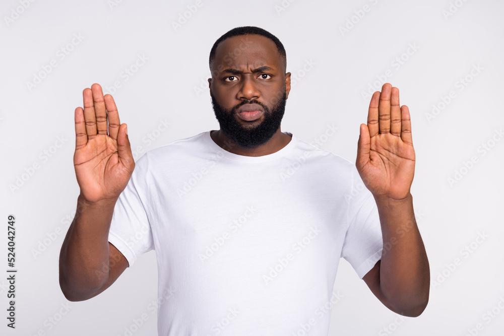 Photo of serious confident man wear casual t-shirt rising arms palms asking stop isolated white color background Photo of serious confident man wear casual t-shirt rising arms palms asking stop isolated white color background