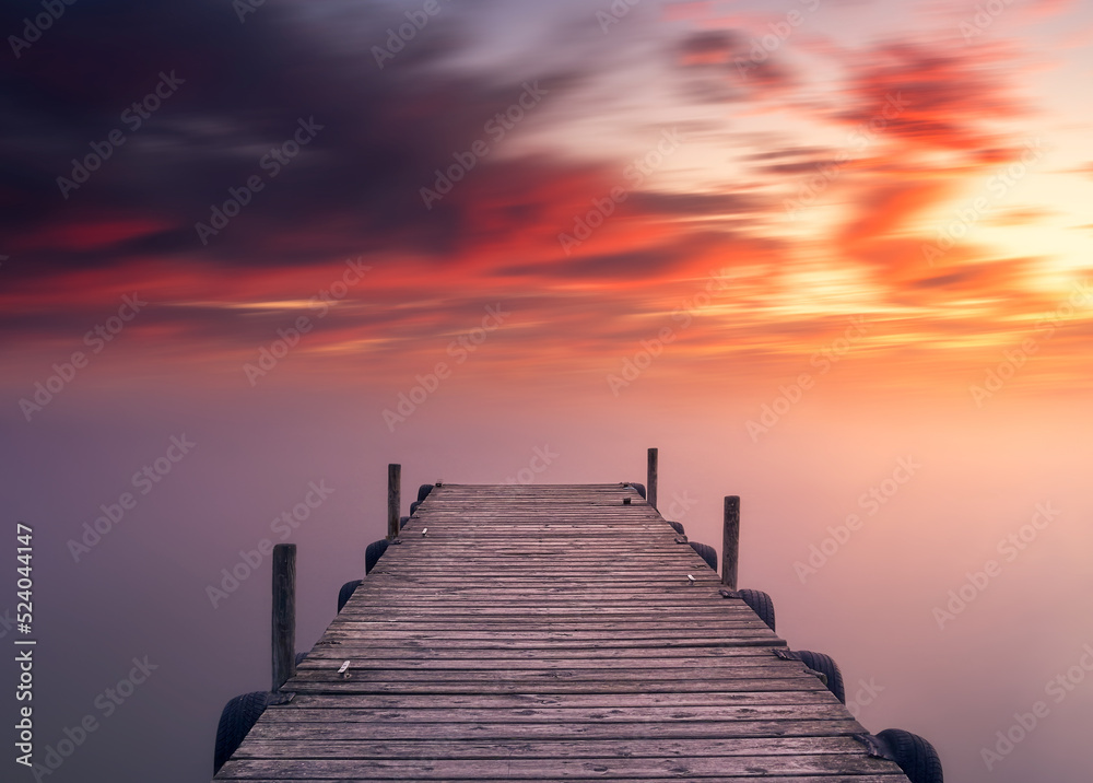 Beautiful landscape and colorful sunset view from the shore with a wooden pier, Albufera, Valencia
