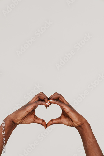 Fototapet Female hands of african woman showing heart gesture with fingers