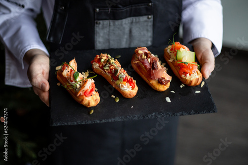 Eclairs with salmon, fresh vegetables and herbs, gourmet snacks.