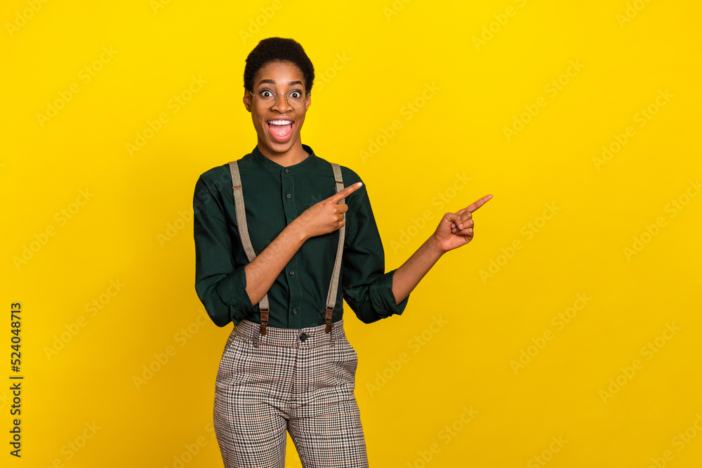 Portrait of attractive cheerful woman demonstrating copy space isolated over bright yellow color background Portrait of attractive cheerful woman demonstrating copy space isolated over bright yellow color background