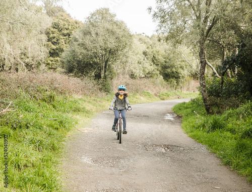 outdoor portrait of a child girl riding a bike, active lifestyle, reacreation leisure time on natural background photo