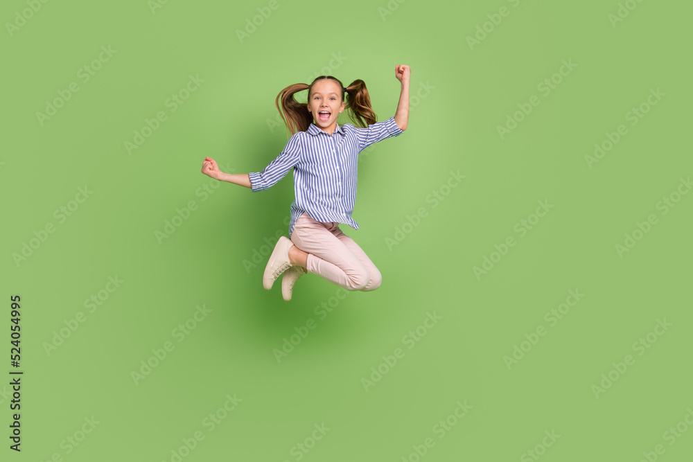 Full length photo of carefree kid girl enjoy e sport bet fist up jump luck triumph isolated vibrant color background Full length photo of carefree kid girl enjoy e sport bet fist up jump luck triumph isolated vibrant color background