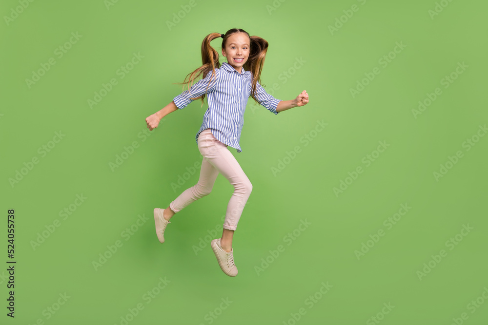 Full size profile side photo of cute kid jump high active run jogging wear striped shirt isolated bright color background Full size profile side photo of cute kid jump high active run jogging wear striped shirt isolated bright color background