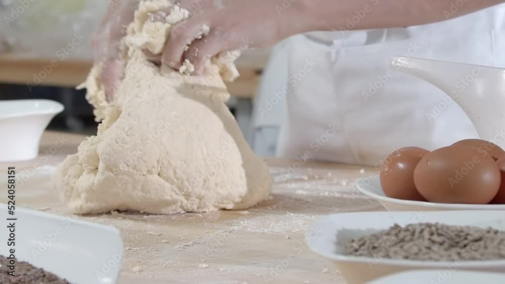 Close-up of dough kneaded by baker on a wooden board sprinkled with flour Close-up of dough kneaded by baker on a wooden board sprinkled with flour