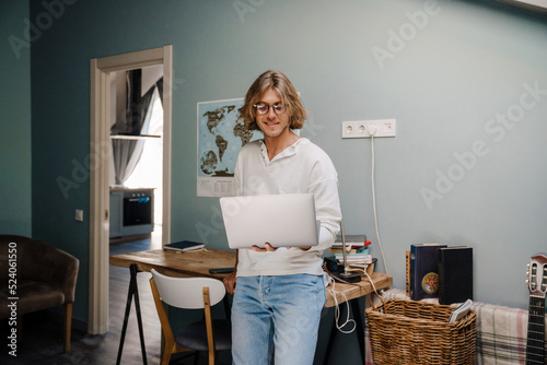 Blonde bristle man typing on laptop while working at home