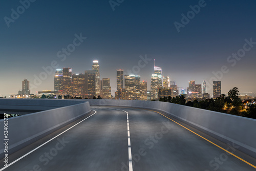 Empty urban asphalt road exterior with city buildings background. New modern highway concrete construction. Concept of way to success. Transportation logistic industry fast delivery. Los Angeles. USA.