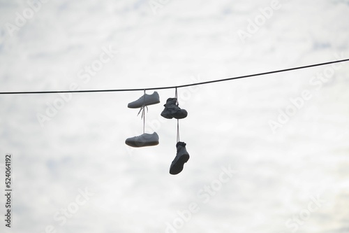 Low angle shot of a pair of shoes dangling from a wire