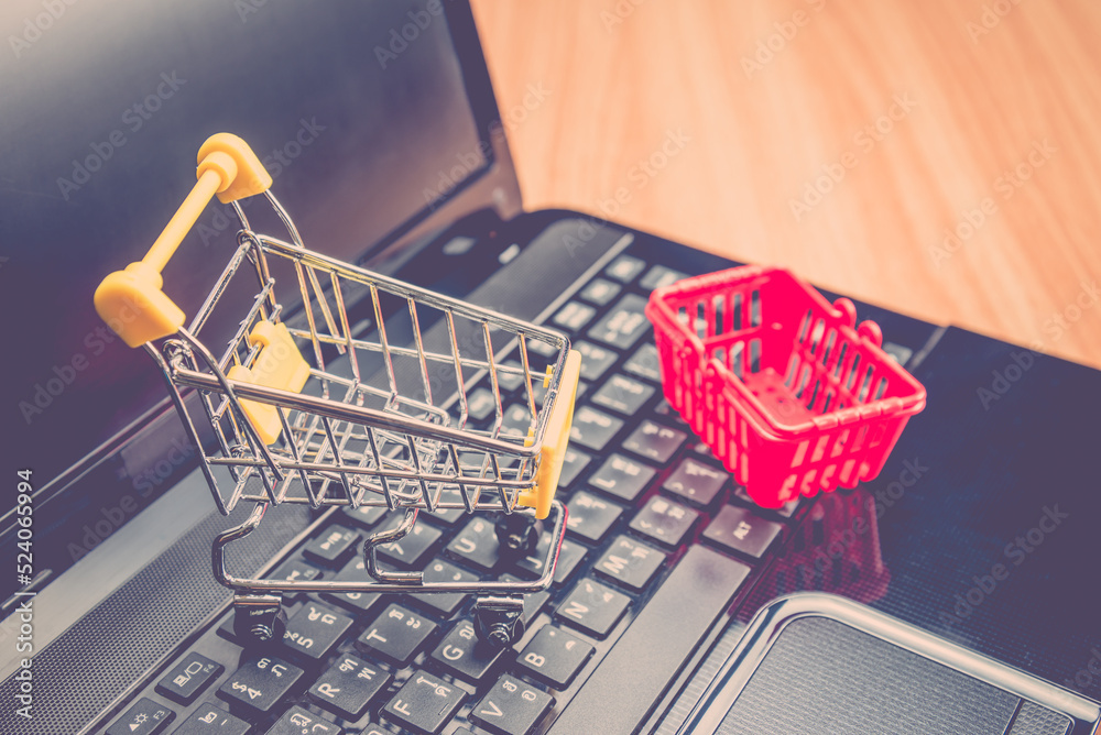 Grocery basket and shopping cart on laptop. Worldwide online shopping b2c e-commerce on internet website at home. Customer can buy product items and delivery service 24 hrs from online store website.