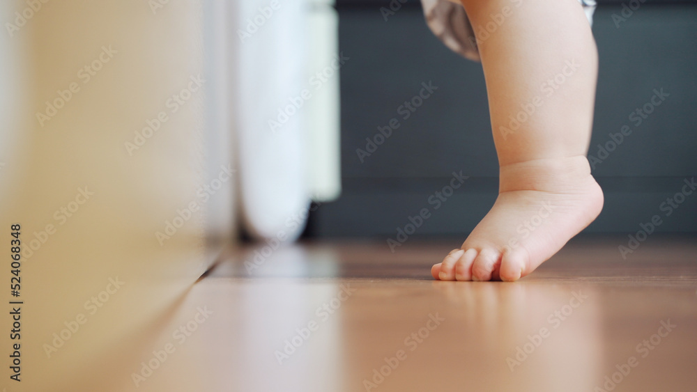 Little toddler learning to stand on the wooden floor, Baby feet. Little toddler learning to stand on the wooden floor, Baby feet.