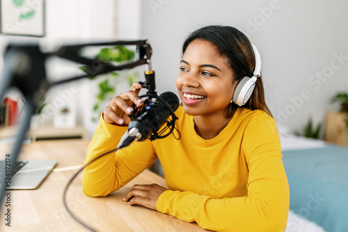 Young ethnic woman recording radio podcast - Millennial female content creator working from home studio - Creative people and freelancer lifestyle concept photo