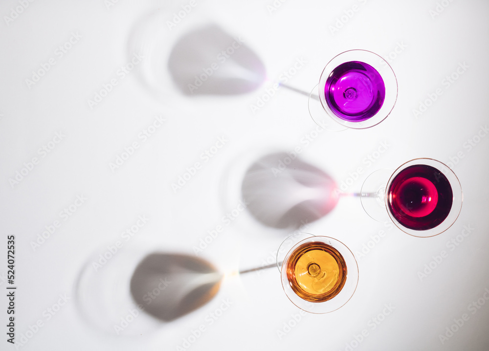 Three glasses with big shadows on light background. Festival time. Creative minimal concept lay out with top view. Flat lay. Three glasses with big shadows on light background. Festival time. Creative minimal concept lay out with top view. Flat lay.
