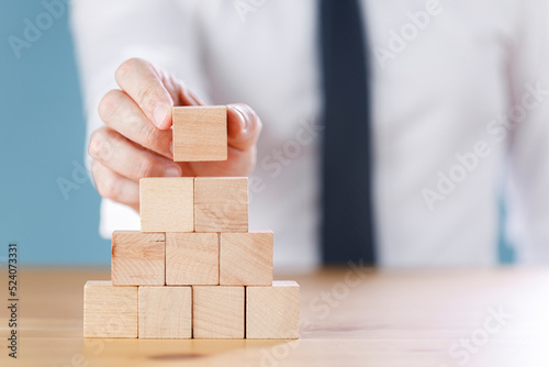 Close up shot of a businessman building cube blocks. Business concept growth success process.