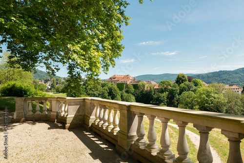 Stone balusters in the park with lush green trees under blue sky