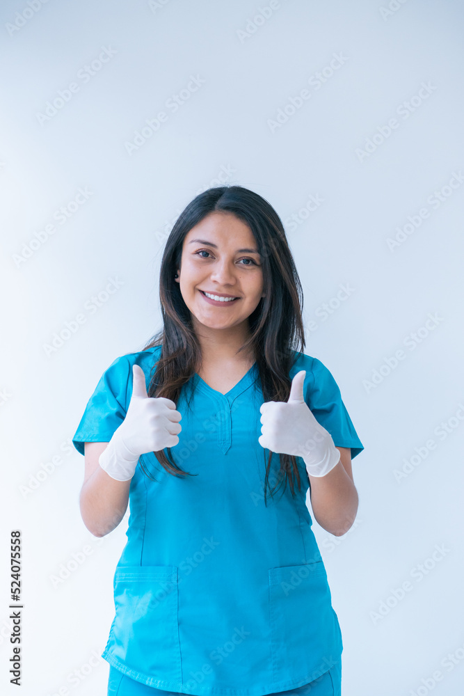 Smiling young Hispanic nurse showing thumbs up in hospital Smiling young Hispanic nurse showing thumbs up in hospital