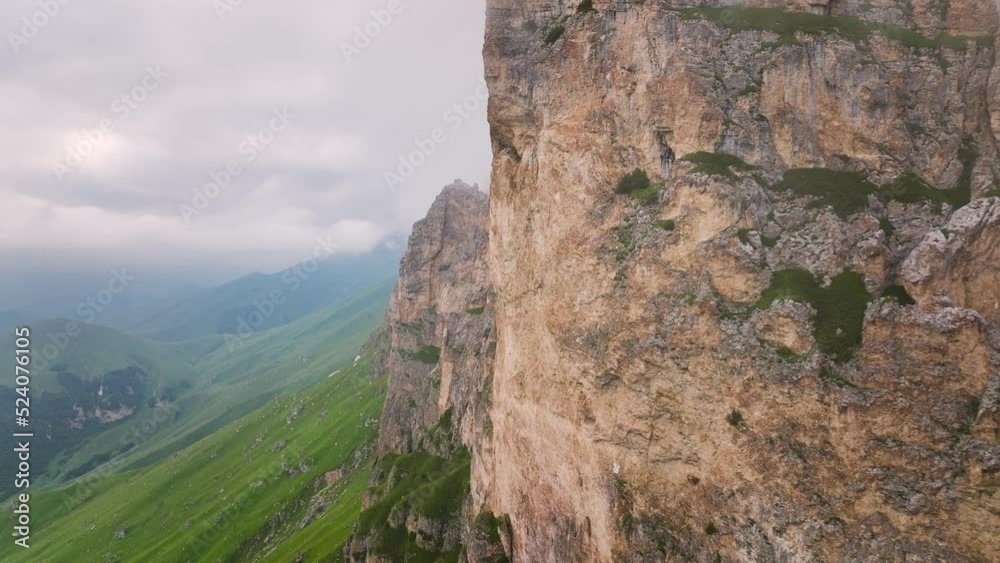 Close-up of a stone mountain in summer. Rock with forest. Bird's-eye. Aerial view of low cloudiness in cloudy weather Close-up of a stone mountain in summer. Rock with forest. Bird's-eye. Aerial view of low cloudiness in cloudy weather