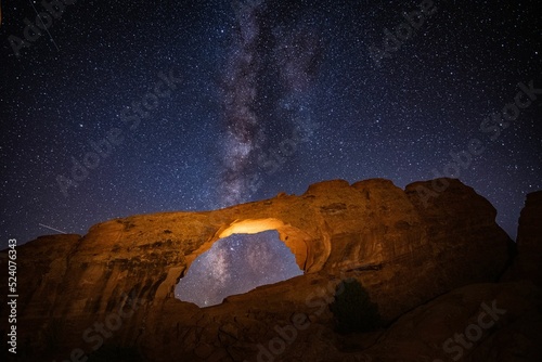 Beautiful shot of a stone arch formation under a milky way galaxy sky photo