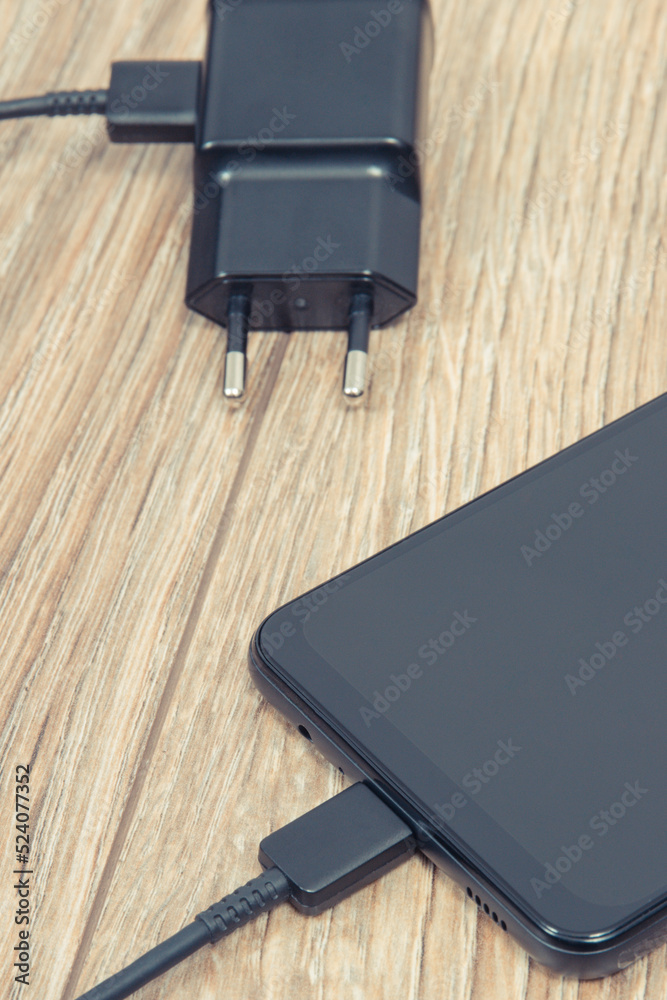 Smartphone and charger using to charge empty battery. Various devices charging concept